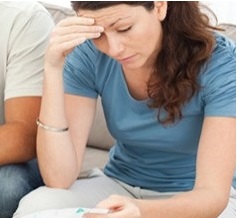 A woman reading a bill and looking worried.
