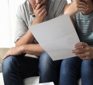 a couple reading a letter and looking concerned